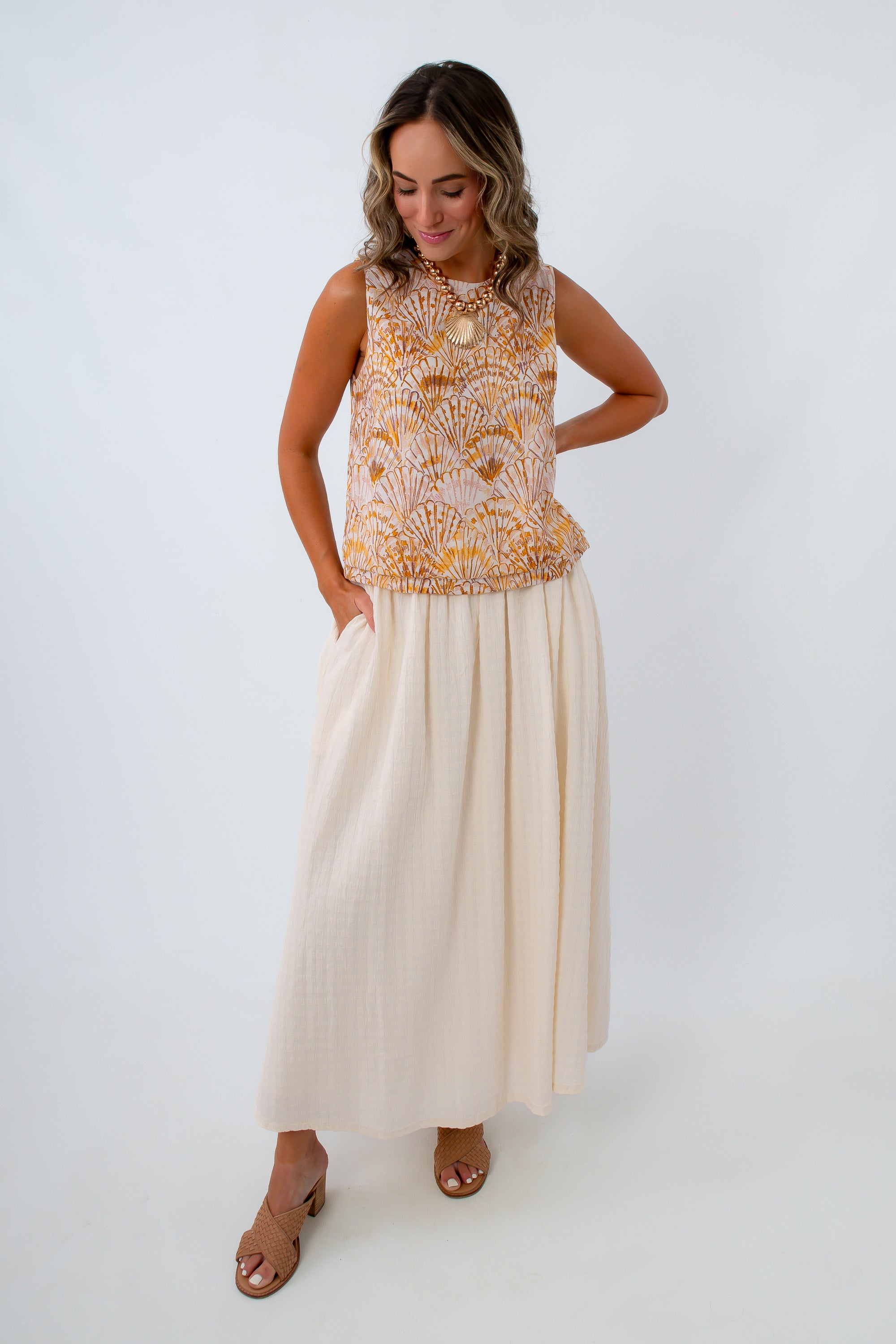Cream and orange shell print top paired with cream maxi skirt for a classic summer look