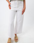 Close-up of white high-waisted denim jeans with front pockets and belt loops