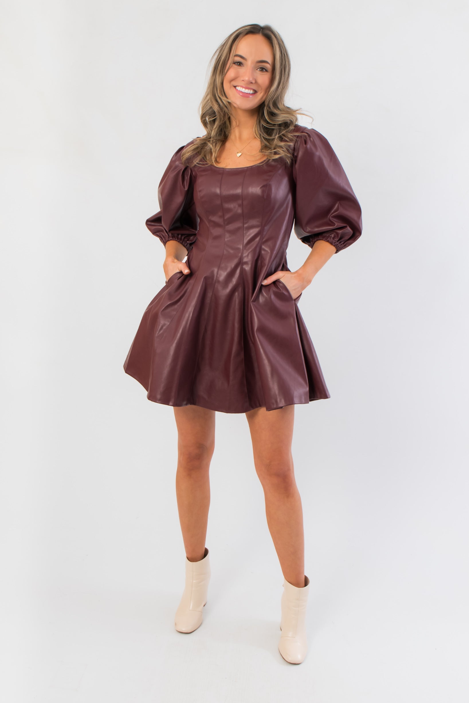 Holiday-ready Bordeaux Bliss Faux Leather Dress featuring side pockets, puff sleeves, and a flattering fit-and-flare silhouette.