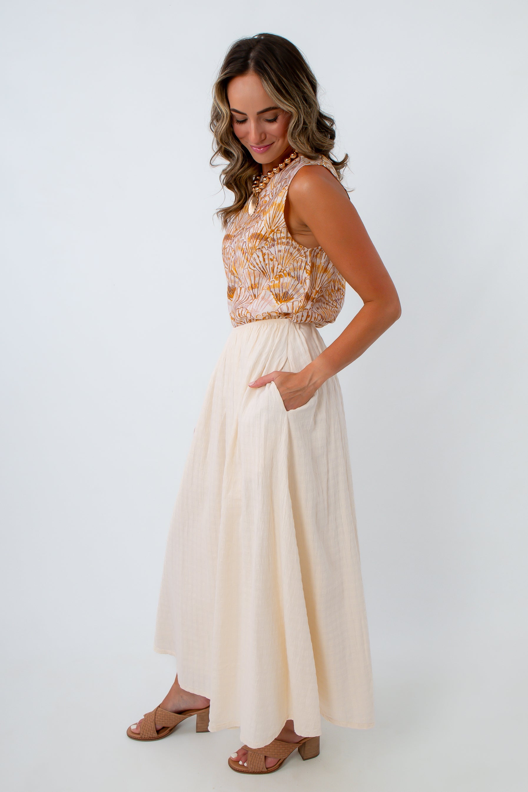 Cream midi skirt with side pockets paired with a seashell printed sleeveless top for the perfect summer workwear look