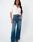 Model wearing white denim contrast stitch short sleeve top with high-waisted jeans