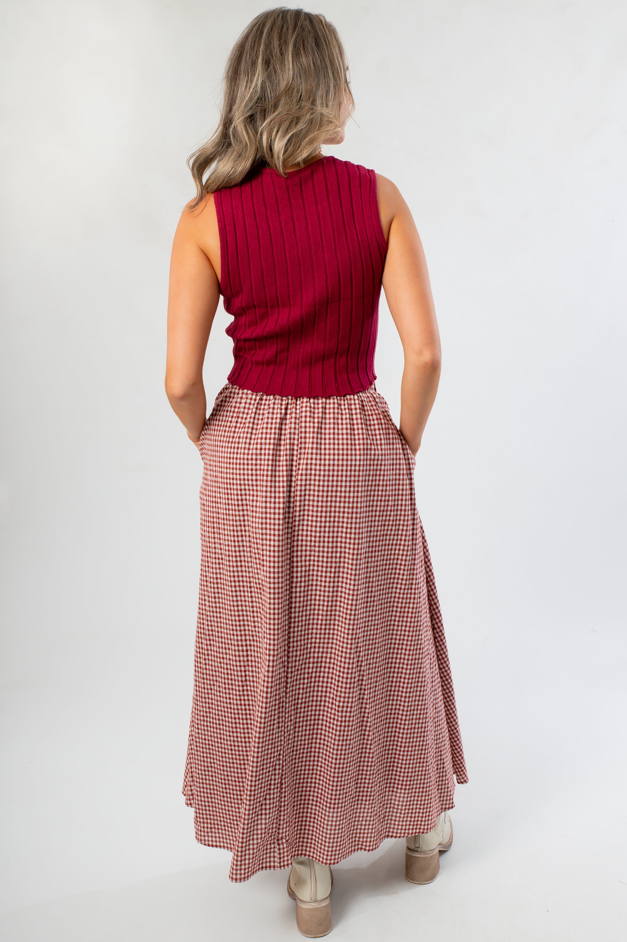 Back view of Wine &amp; Dine Rib Sleeveless Sweater showing ribbed texture and cropped fit, paired with a gingham skirt for a stylish outfit.