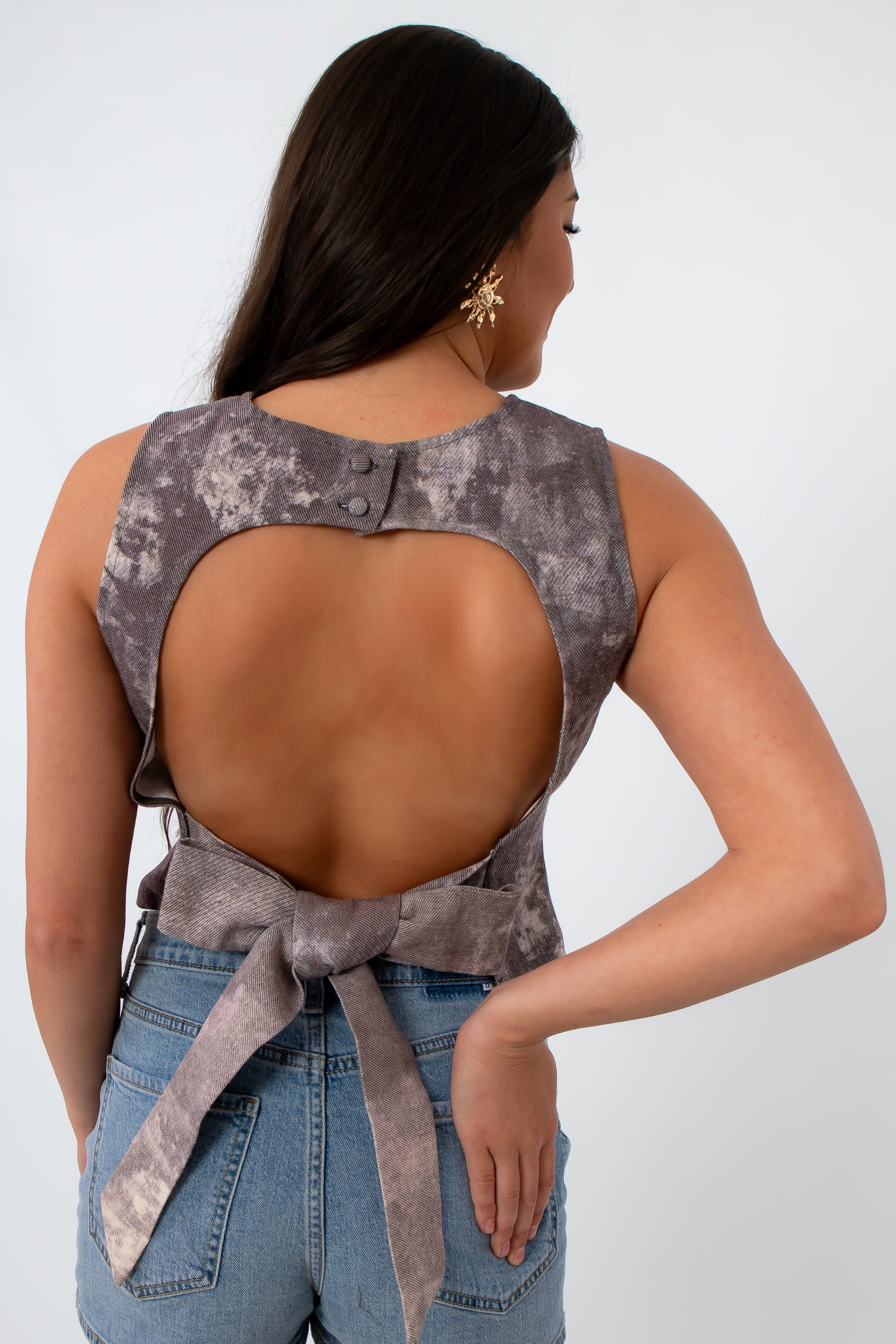 Back view of sleeveless denim top with open-back design and tie detail