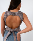 Back view of sleeveless denim top with open-back design and tie detail