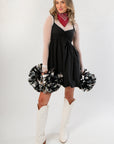 Black Hem Mini Dress styled with white boots and pom-poms, featuring a bubble hem and layered mesh sleeves for a trendy gameday look.