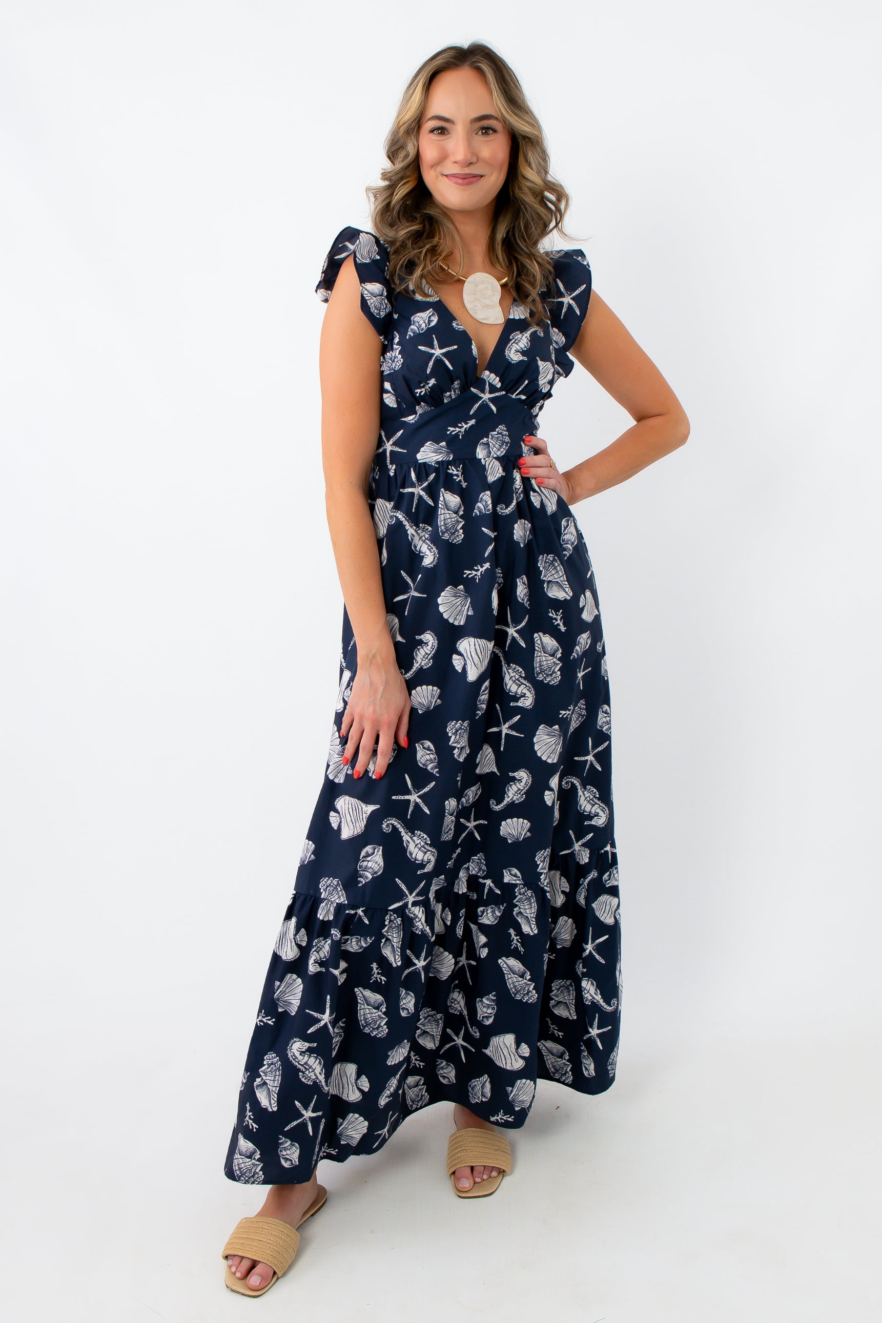 Back view of navy seashell print maxi dress with bow tie and ruffle sleeves