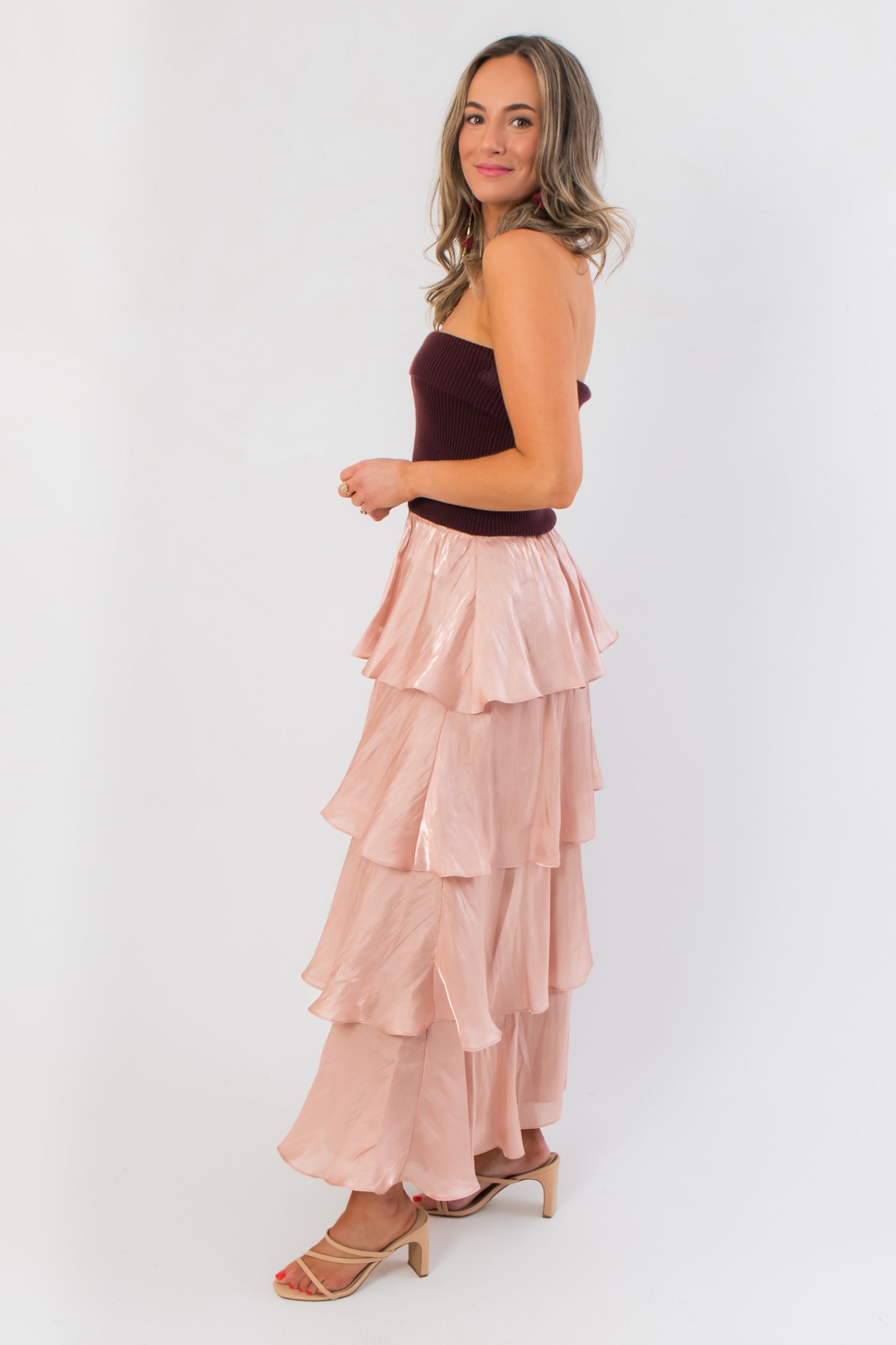 Side view of Designed to Shine Wine Strapless Tiered Midi Dress showing cascading blush satin layers and a sleek strapless fit for festive occasions.