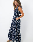 Side view of navy seashell print maxi dress with tie back and ruffle details