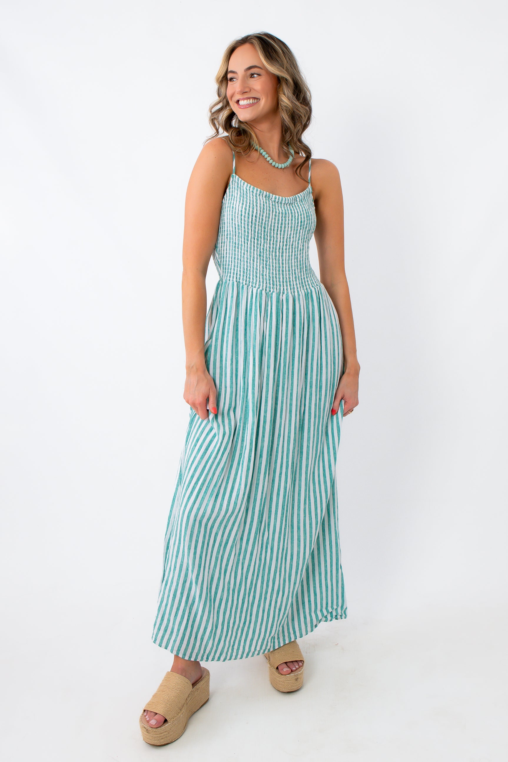 Side view of turquoise striped midi dress with flowy skirt and casual style
