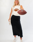 Ned Bedazzled Football Sweater in sleeveless white knit with rhinestone football graphic, styled for game day with black skirt and sneakers.