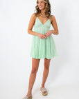 Model wearing Seafoam Siren Lace Babydoll Mini Dress with layered necklaces, casual summer look, light green lace dress