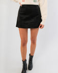 Z Supply Black Suede Mini Skirt styled with cream sweater and black boots, perfect for trendy fall and winter outfits.