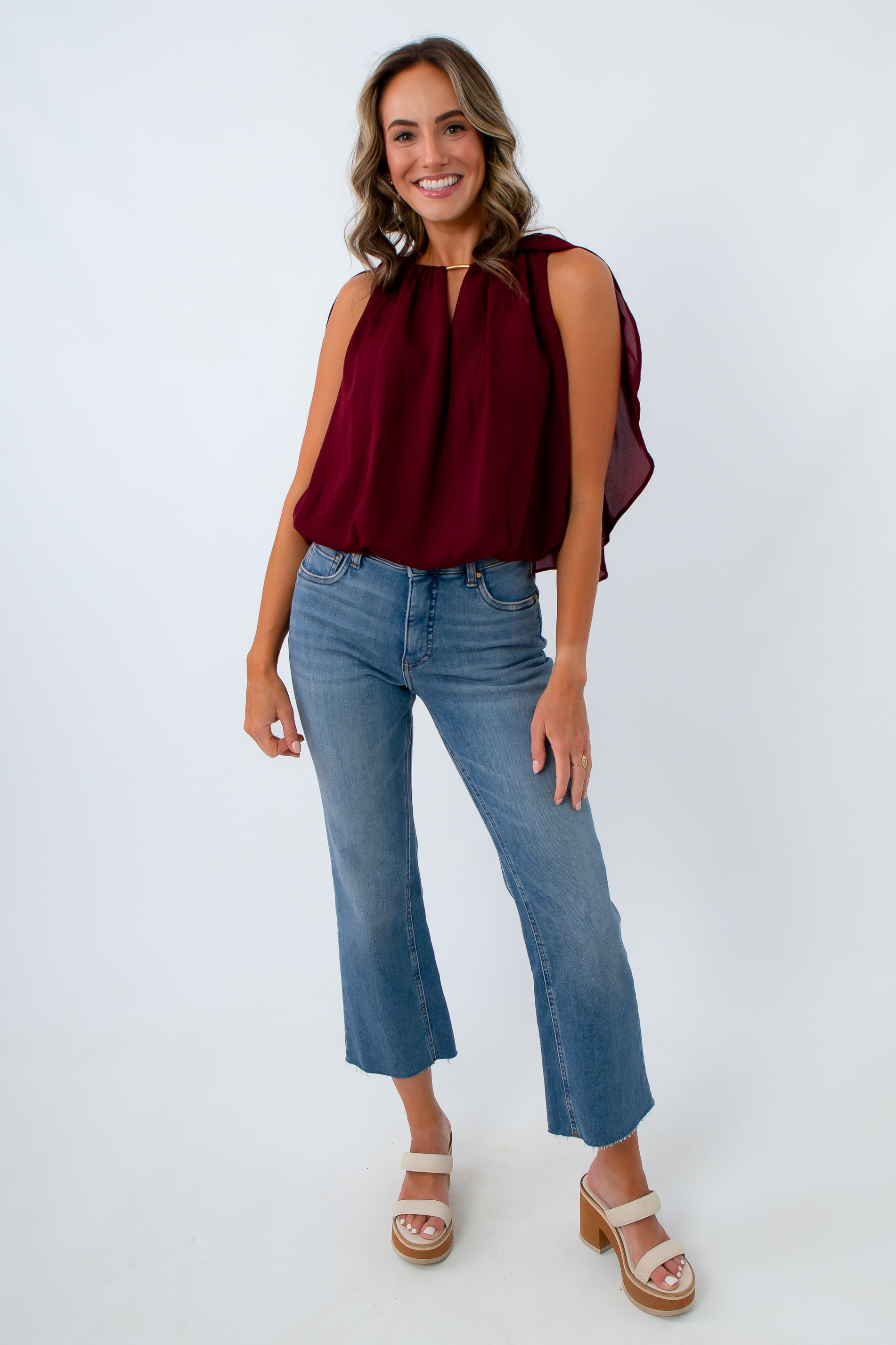 Fashionable fall blouse for women that features a bubble hem and dramatic cape sleeves for fall date night