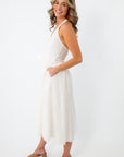 Back view of white eyelet halter midi dress with bow detail