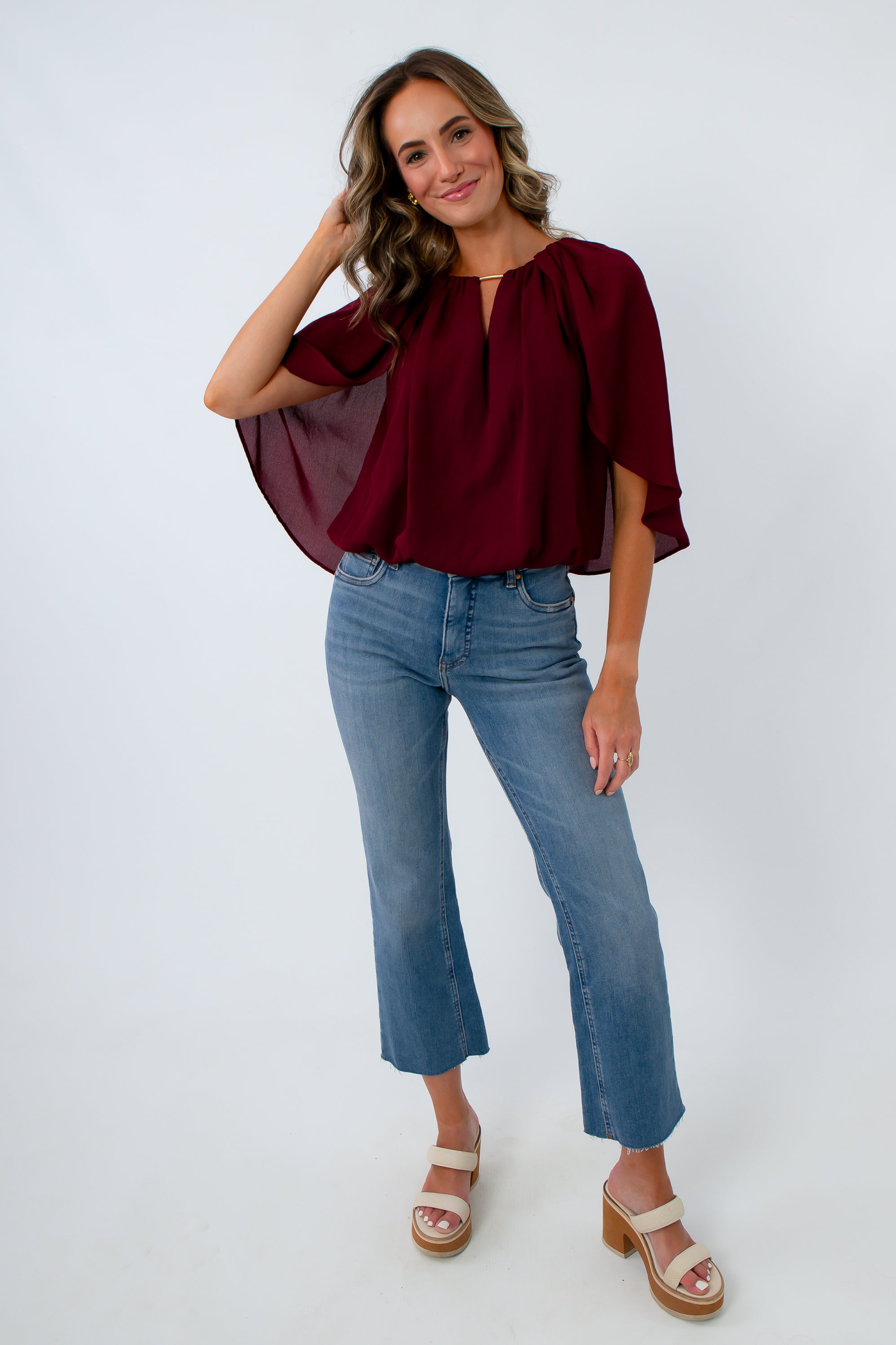 Burgundy bubble hem top with dramatic cape sleeves for fall workwear, dinner, date night, game day