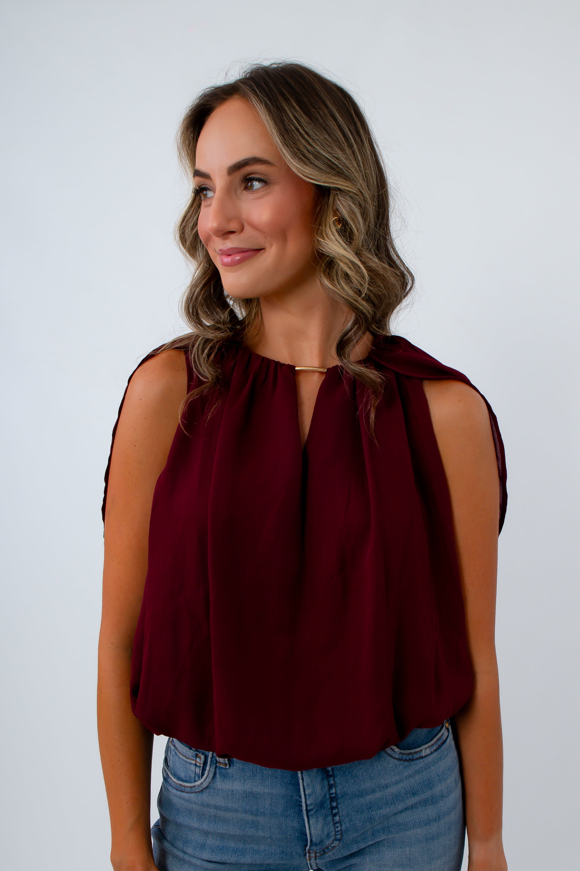 Garnet red blouse with bubble hem and cape sleeves for the perfect fall blouse, game day top, and fall workwear