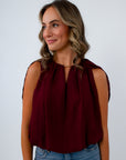 Garnet red blouse with bubble hem and cape sleeves for the perfect fall blouse, game day top, and fall workwear