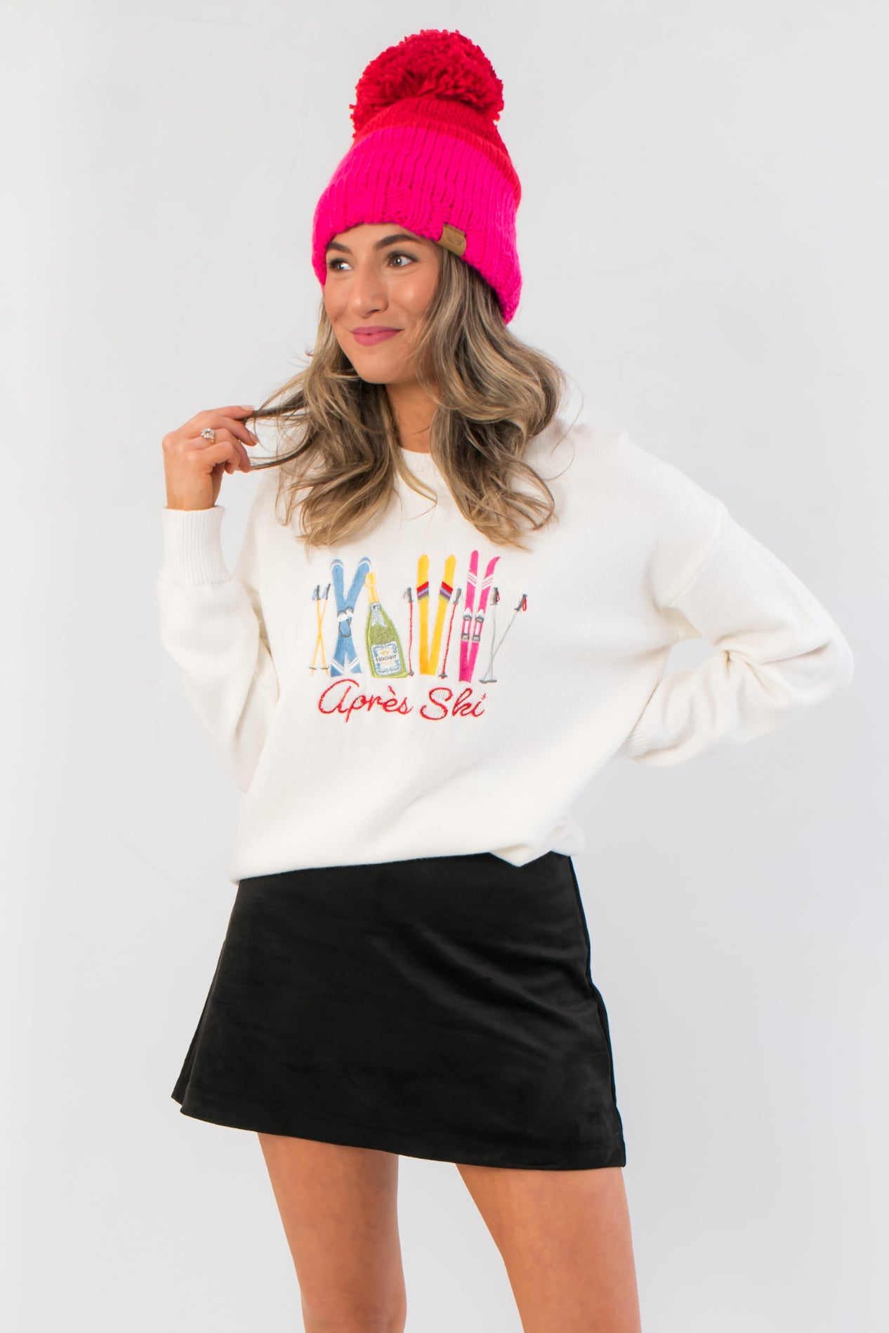 Après Ski White Embroidered Sweater with colorful ski gear design, cozy knit fabric, and relaxed fit, styled for winter layering.