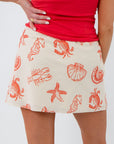 Back view of Sally Red Seashell Printed Mini Skirt showcasing playful red sea creature prints, ideal for vacations and casual wear.
