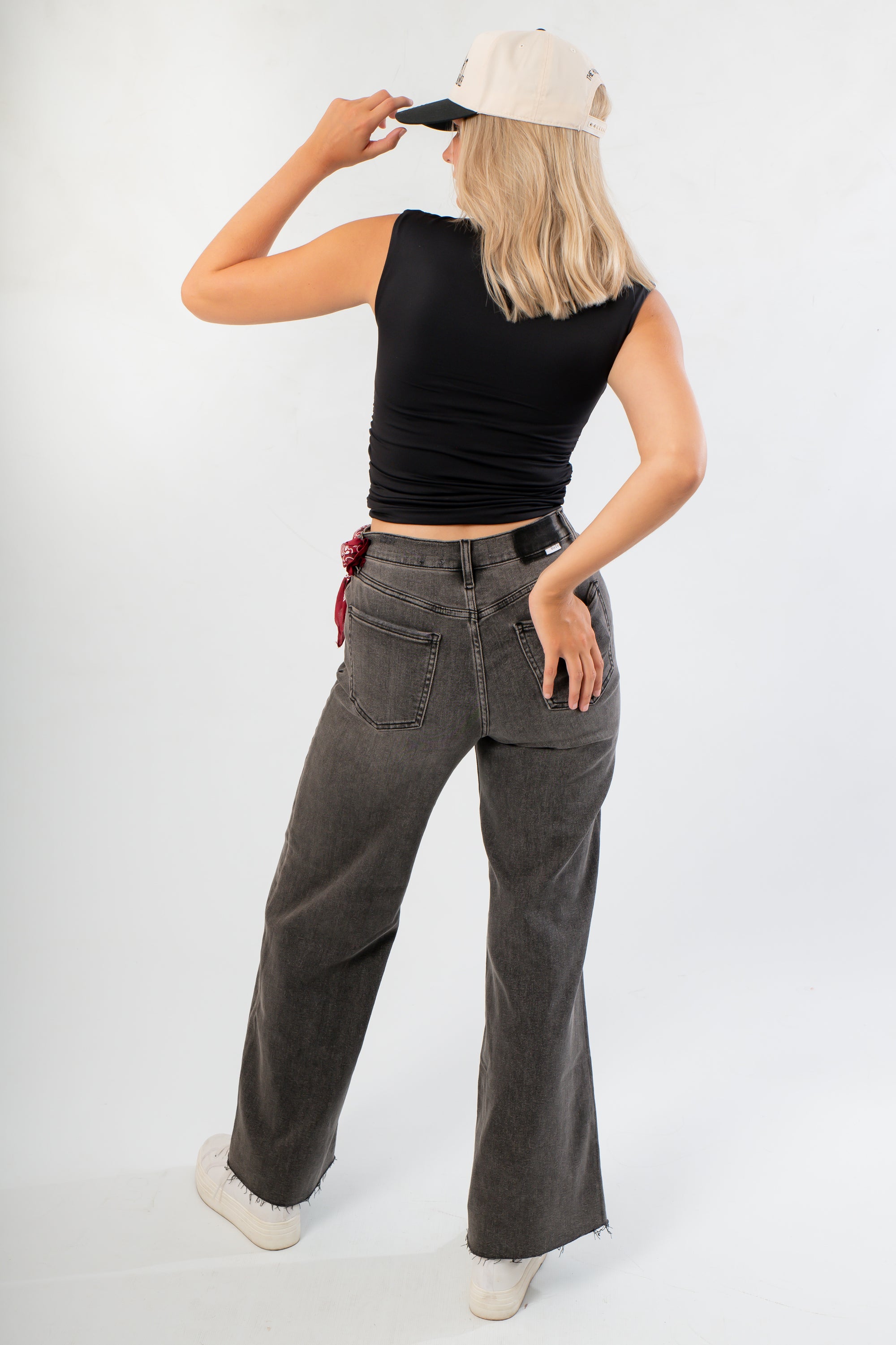 Back view of Luck Of The Draw Black Ruched Funnel Neck Tank – Sleek Fit showing fitted silhouette and sleeveless cut, styled with casual denim.