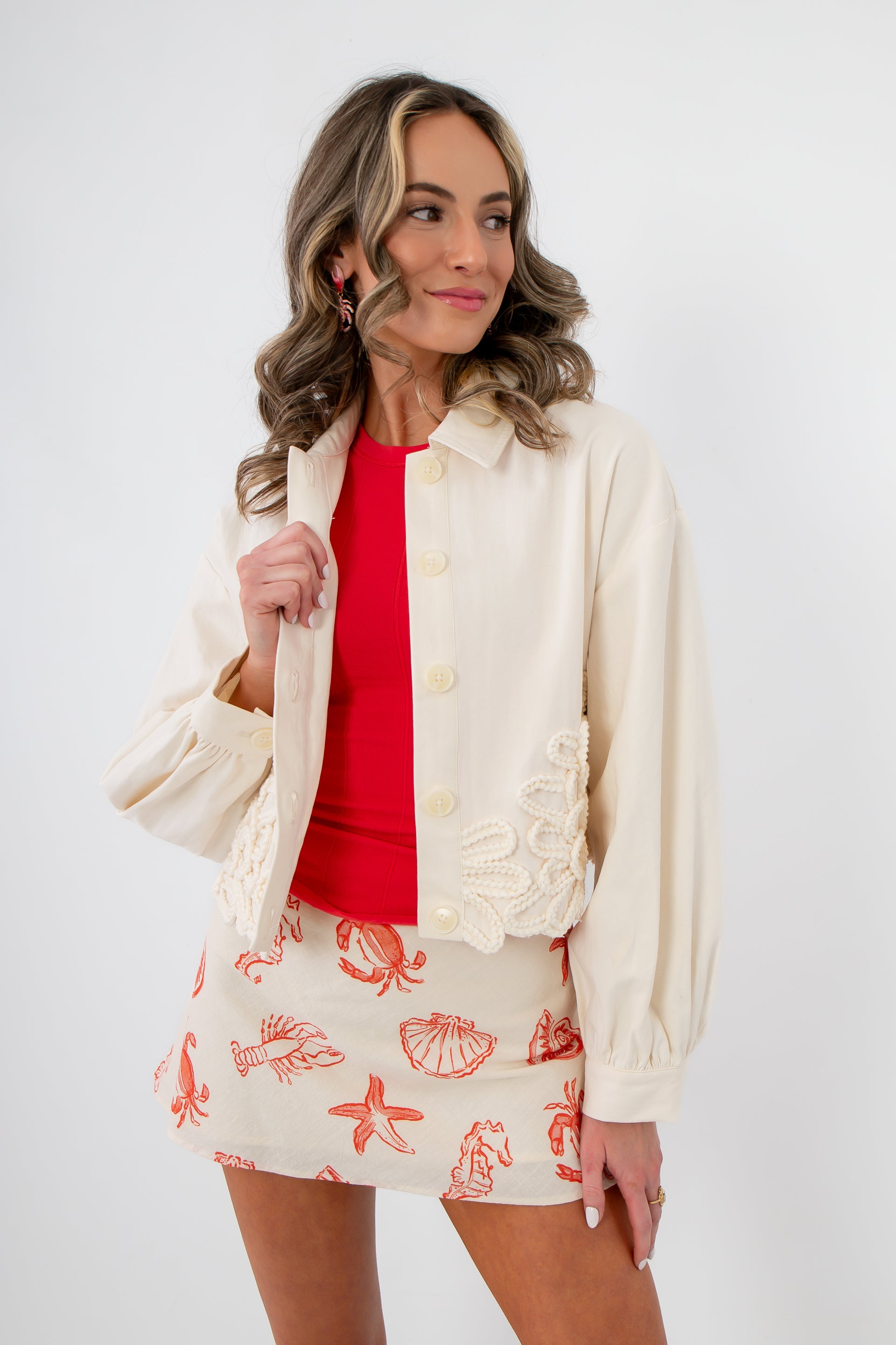 Seagarden Appliqué Floral Detail Jacket in ecru with textured floral appliqué, styled over a red top and printed mini skirt for spring layering.
