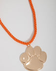 Gameday Jewelry Go Team Gold Clemson Paw Necklace featuring shiny gold paw charm and vibrant orange rope chain, perfect for Clemson fans.