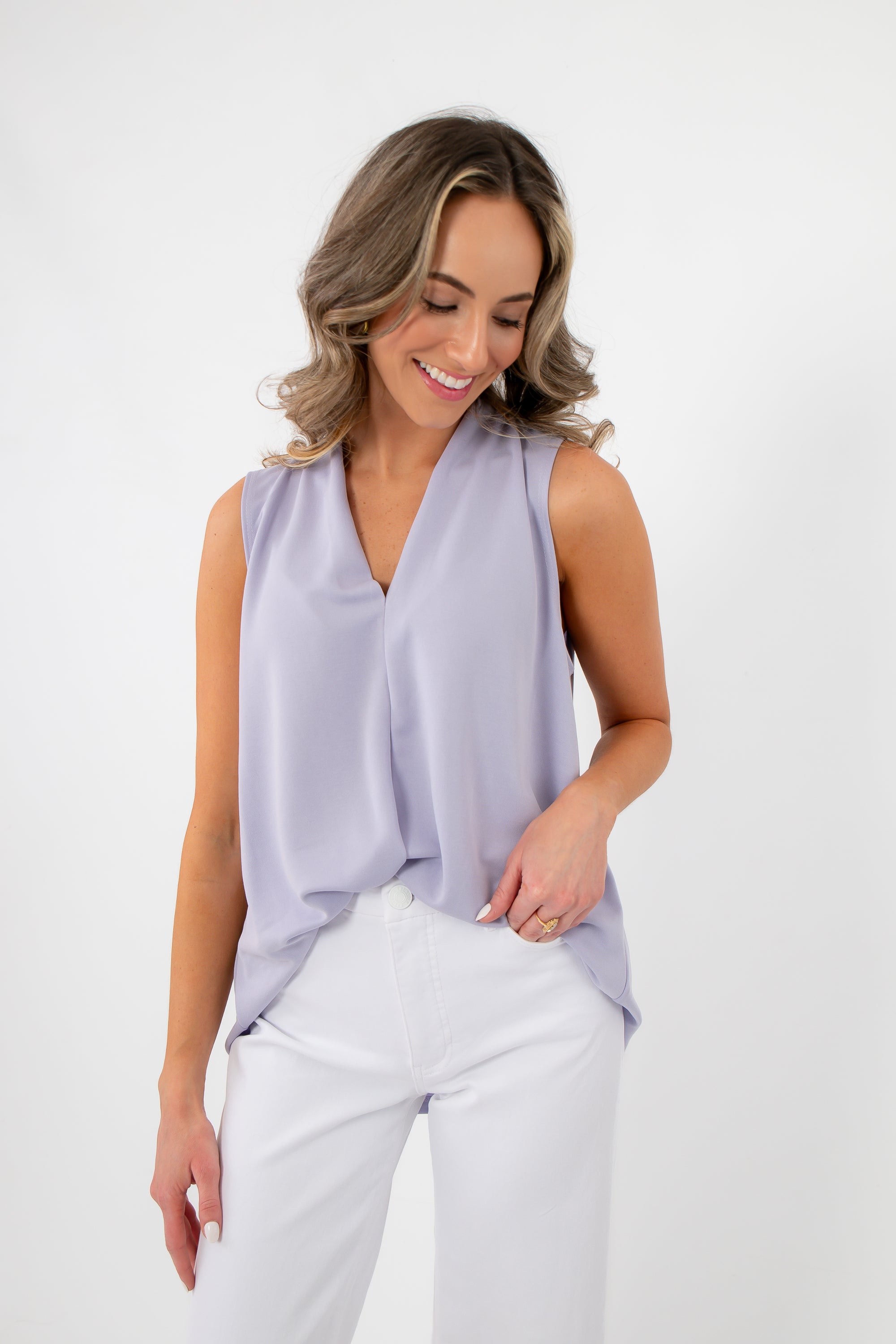 Lavender Mist V-Neck Sleeveless Drape Top styled with white pants, showcasing its soft drape and dressy tank blouse design.