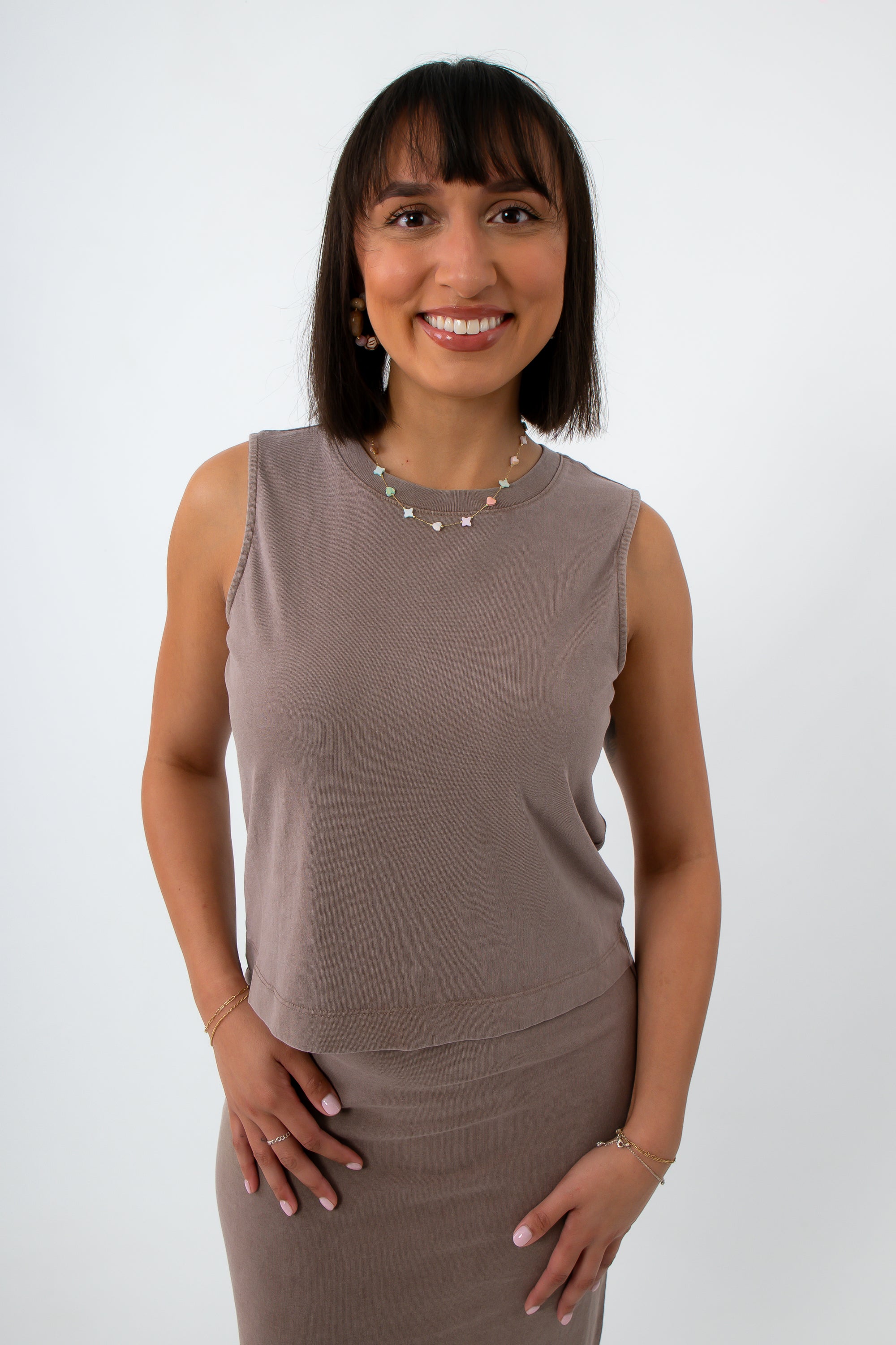 woman wearing taupe sleeveless tank top with jewelry, front view