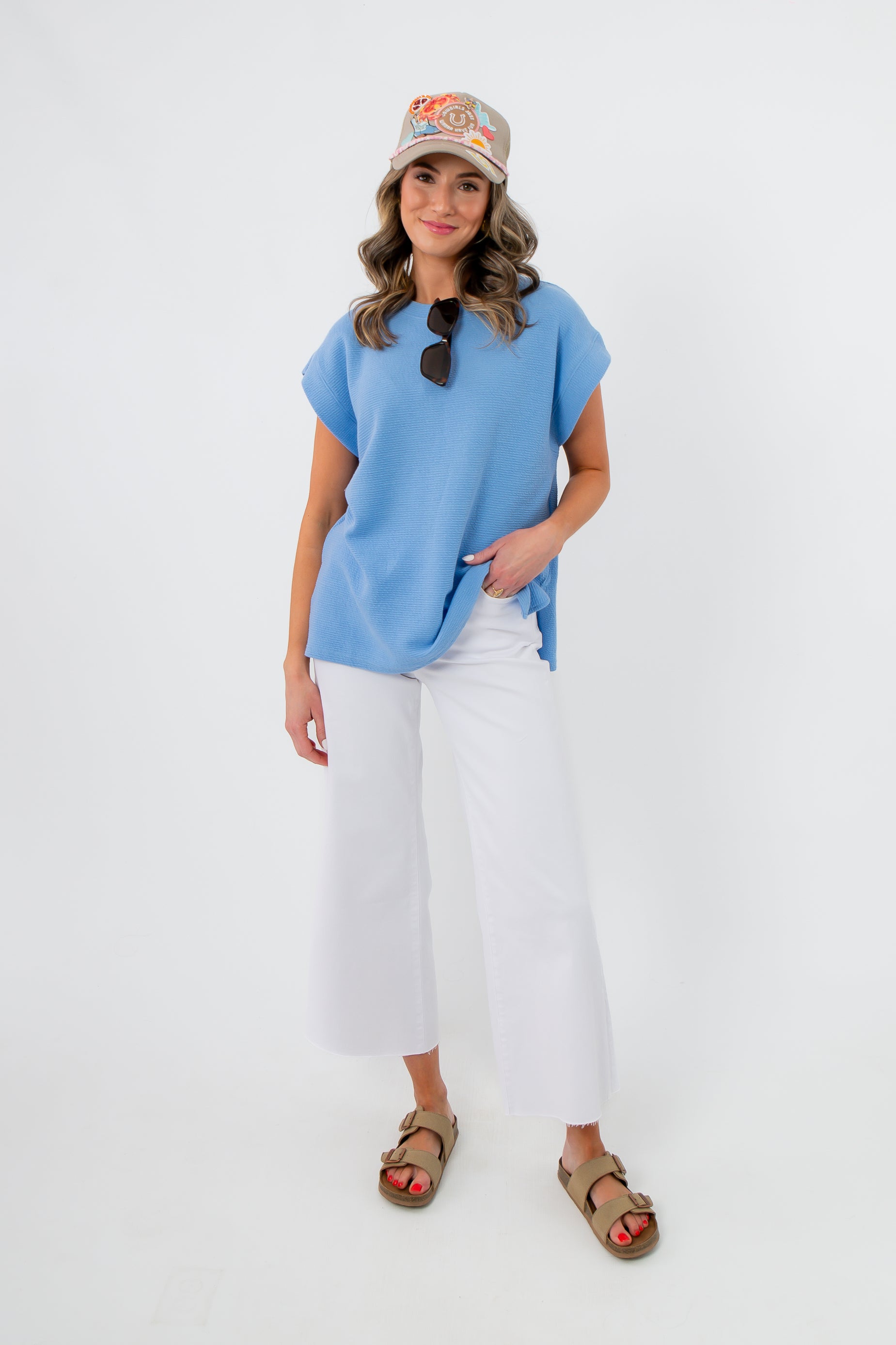 Camila Powder Blue Knit Top styled with white wide-leg pants and sandals, perfect for spring casual wear. Features a relaxed fit and round neckline.