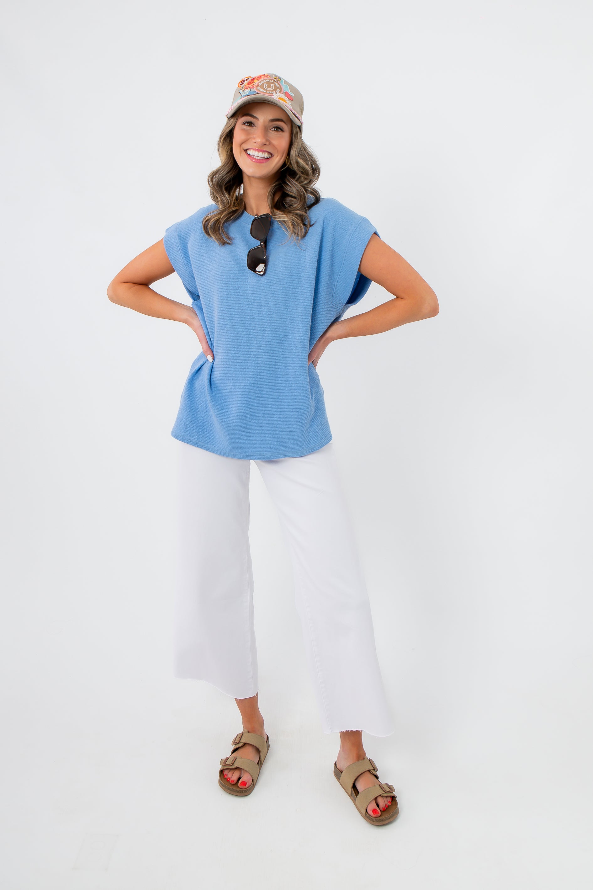 Model wearing Camila Powder Blue Knit Top with hands on hips, showcasing its breezy silhouette and versatile spring style for casual outfits.