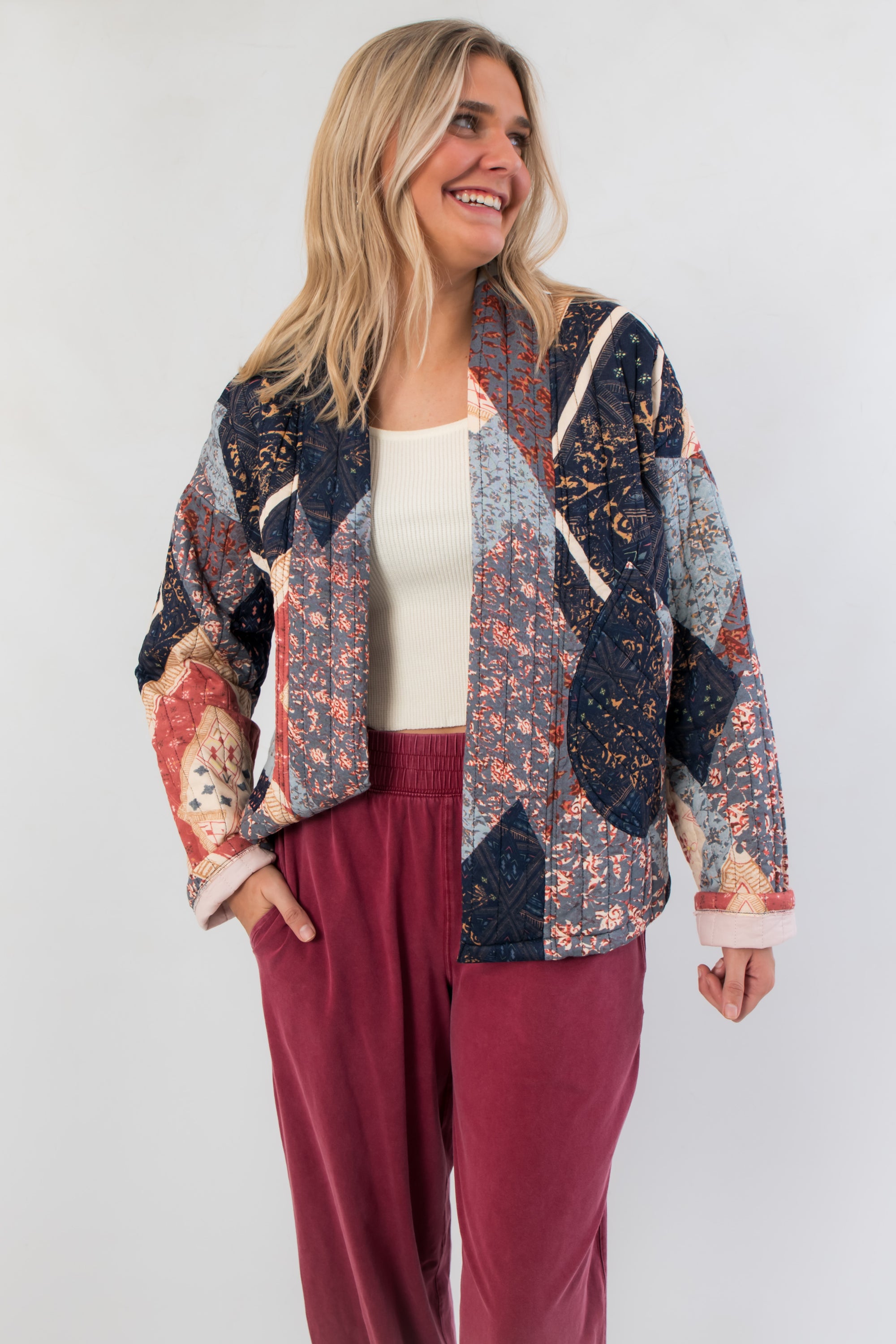 Augusta Patchwork Quilted Jacket in navy and red with geometric fall patterns, styled with relaxed fit and front pockets for cozy layering.