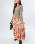 Side view of Burnt Orange Floral Patterned Midi Skirt styled with brown boots and long sleeve top. A must-have for fall fashion lovers.