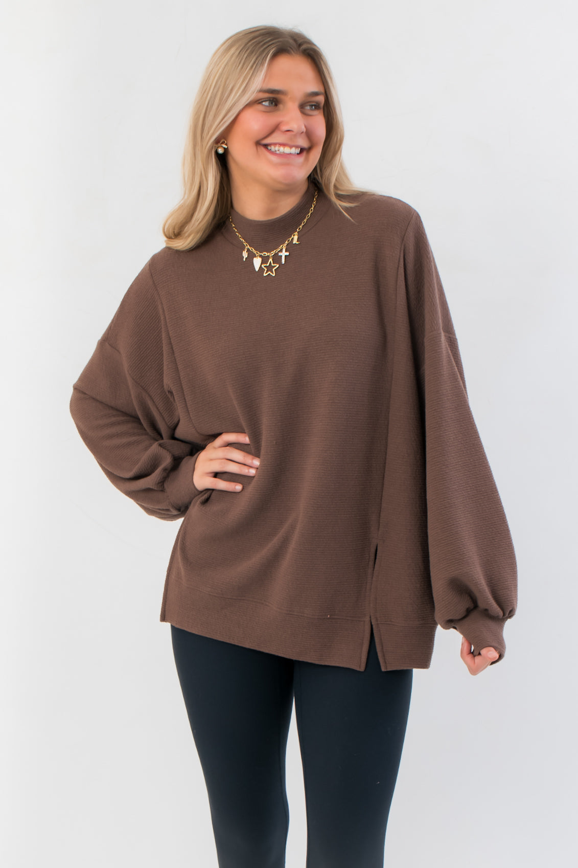 Camden Brown Ribbed Knit Mockneck Top with oversized fit and balloon sleeves, styled with black leggings for a cozy layered look.