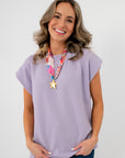 Camila Lavender Knit Top with round neck and cuffed sleeves, styled casually with jeans for a soft spring look.