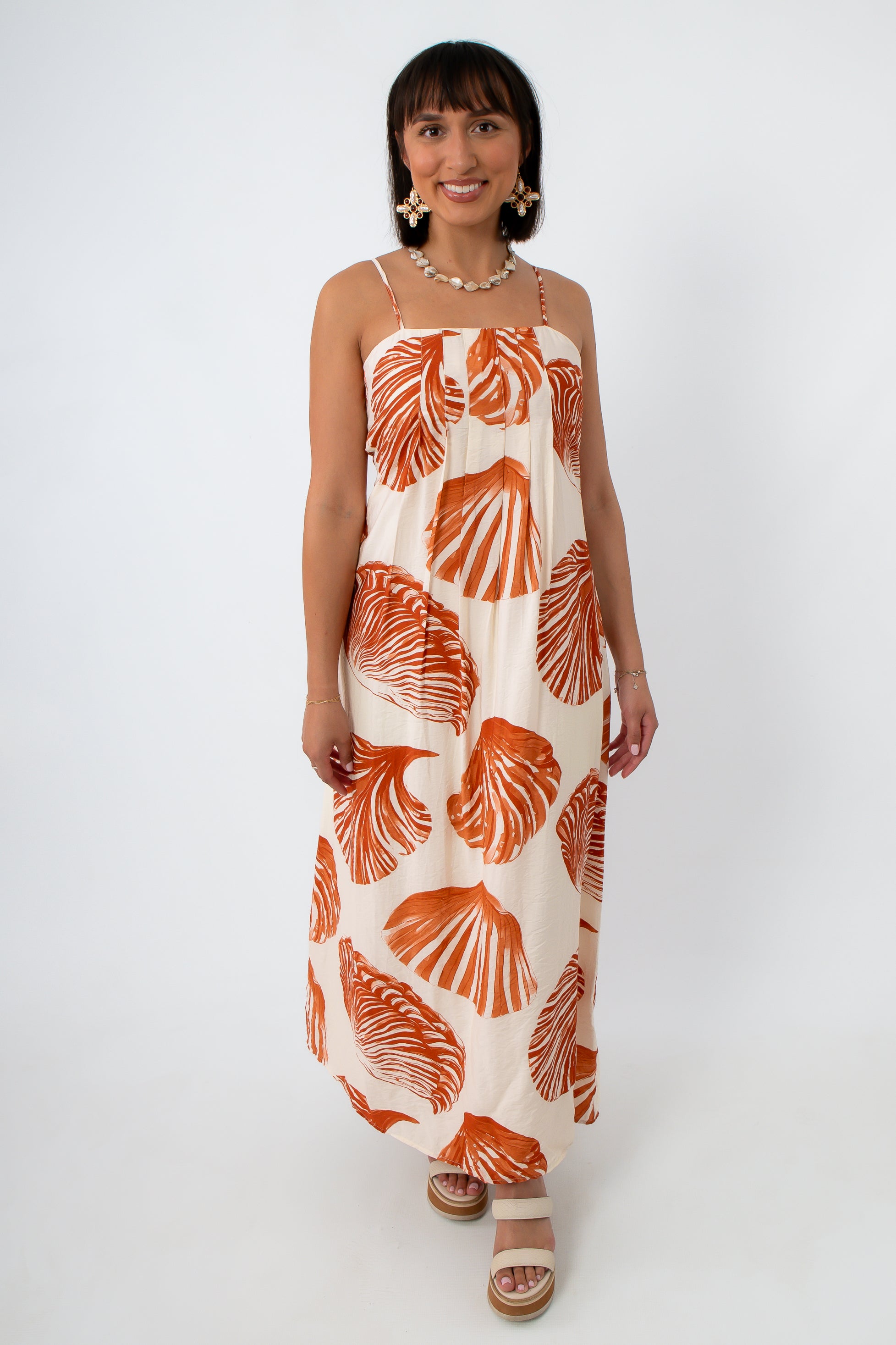 Woman in boho seashell print maxi dress with shell jewelry