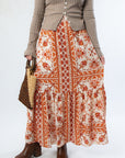 Close-up of Burnt Orange Floral Patterned Midi Skirt with tiered hem and vibrant fall floral print. Ideal for autumn fashion looks.