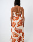 Full length of woman in boho seashell print maxi dress with shell jewelry