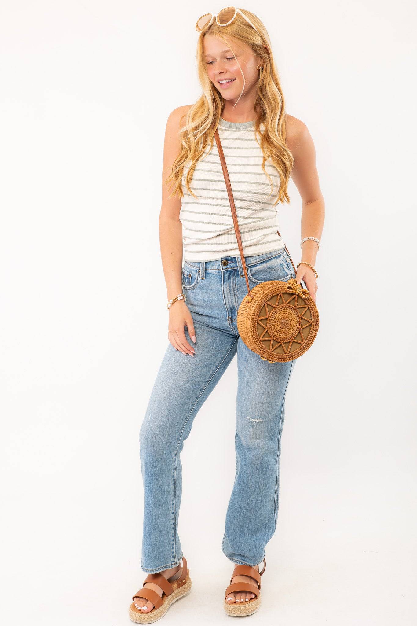 Casual outfit featuring the Z Supply Hadley Sage Green Stripe Tank, accessorized with a round woven bag and layered bracelets for a boho-inspired look.