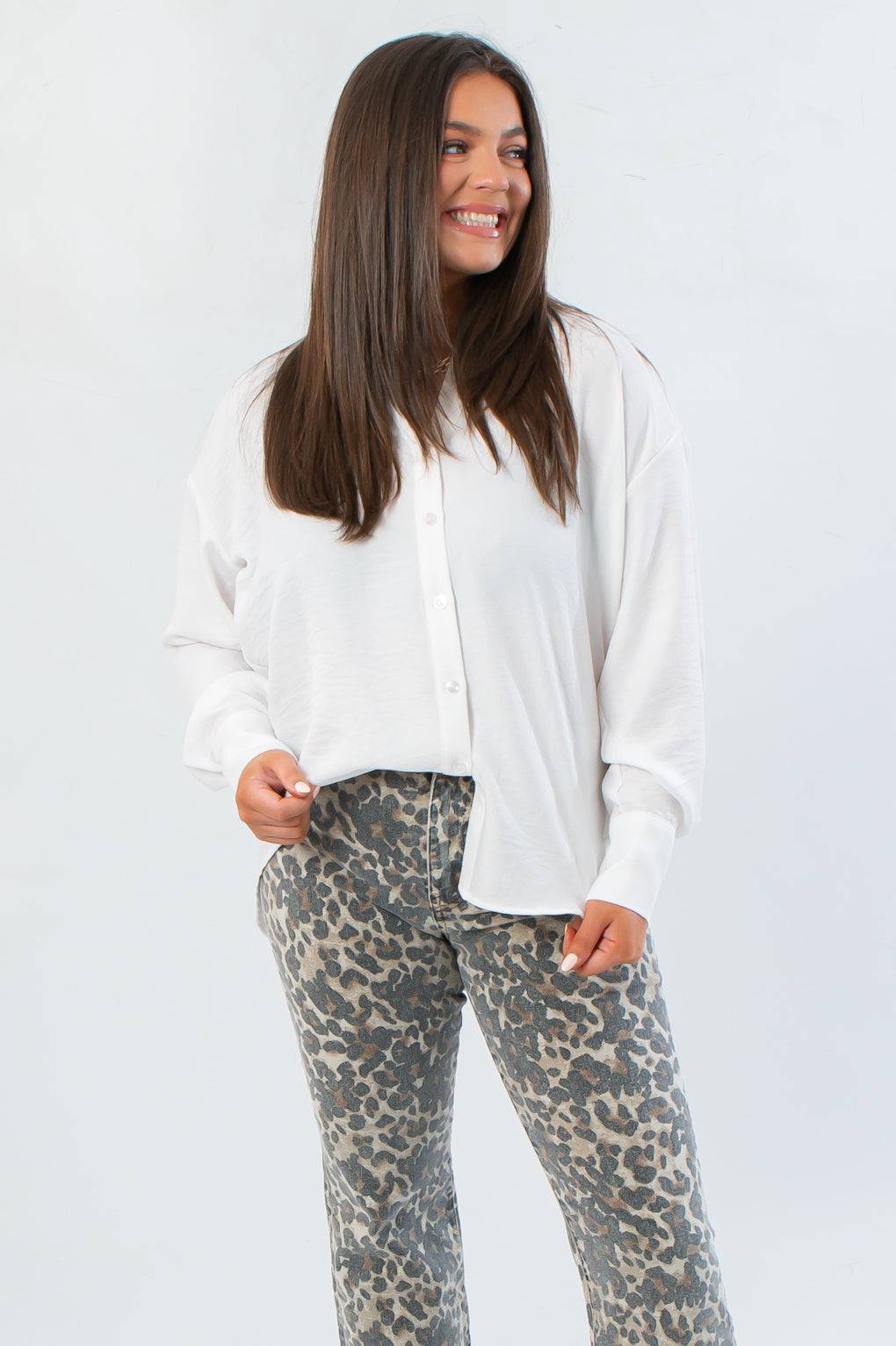 Rylee White Oversized Button Down Shirt with cuffed sleeves and relaxed fit, styled with leopard print pants for a chic workwear look.