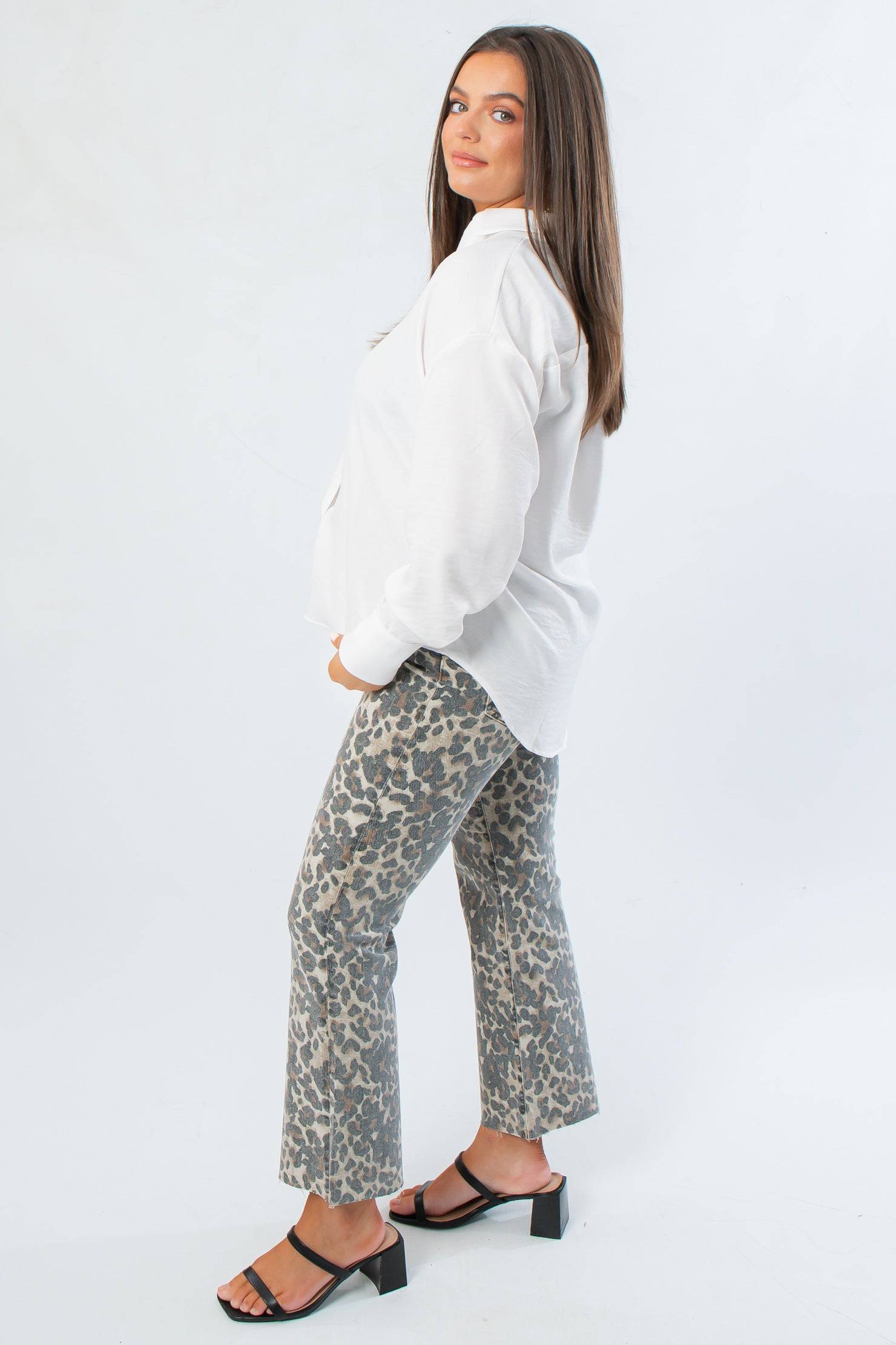 Side view of Rylee White Oversized Button Down Shirt showcasing its loose silhouette and long sleeves, styled for modern workwear.