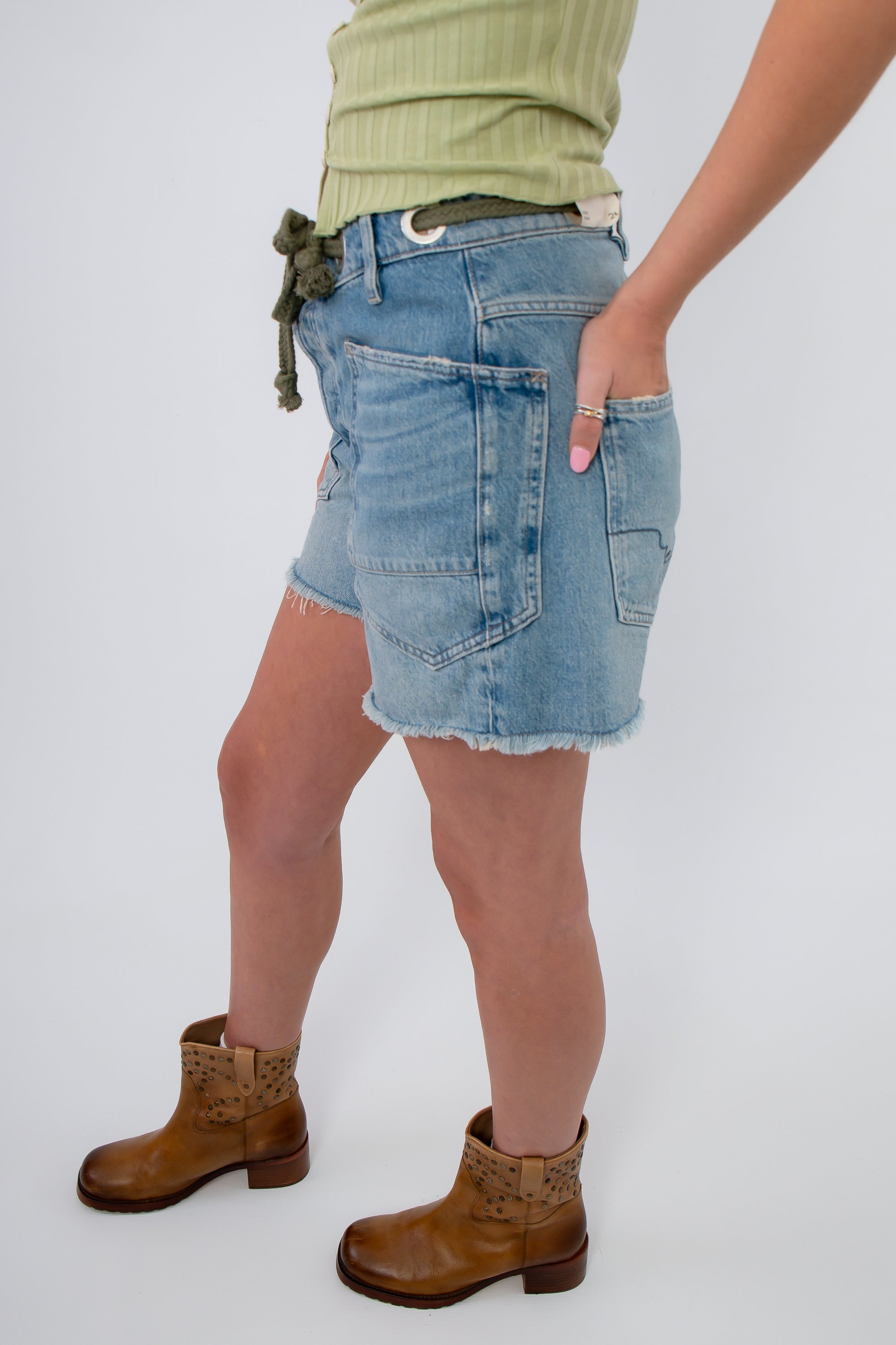Side view of Free People Truest Blue Moxie Shorts featuring oversized pockets and frayed hem, perfect for laid-back denim style.