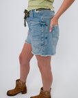 Side view of Free People Truest Blue Moxie Shorts featuring oversized pockets and frayed hem, perfect for laid-back denim style.