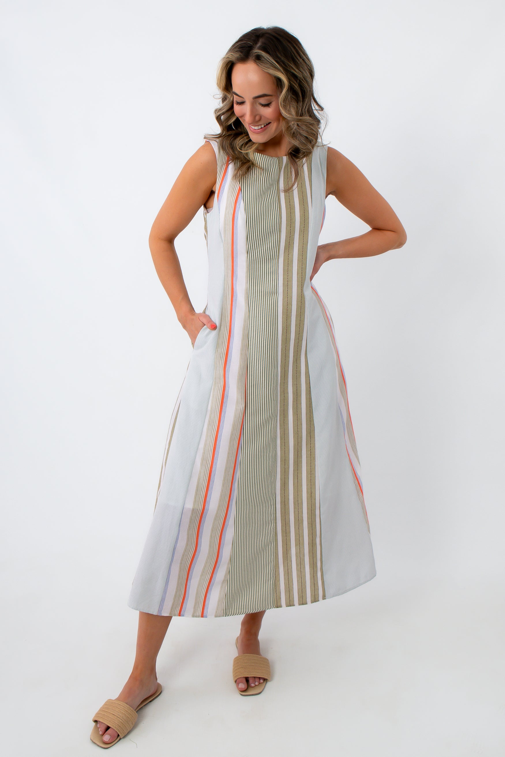 Back view of woman in striped midi dress with hands on hips