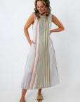 Back view of woman in striped midi dress with hands on hips