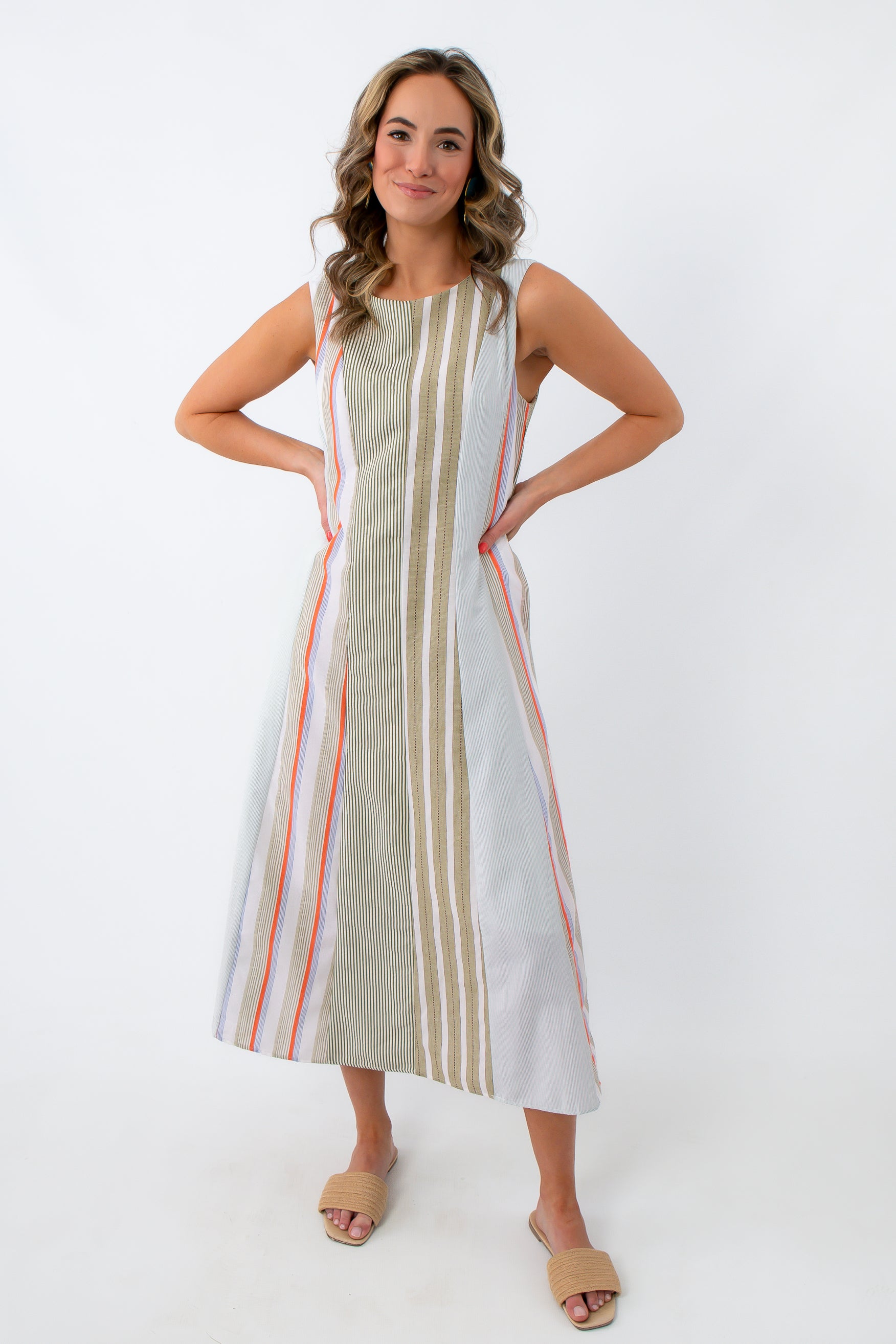 Front view of woman in striped midi dress with hands on hips
