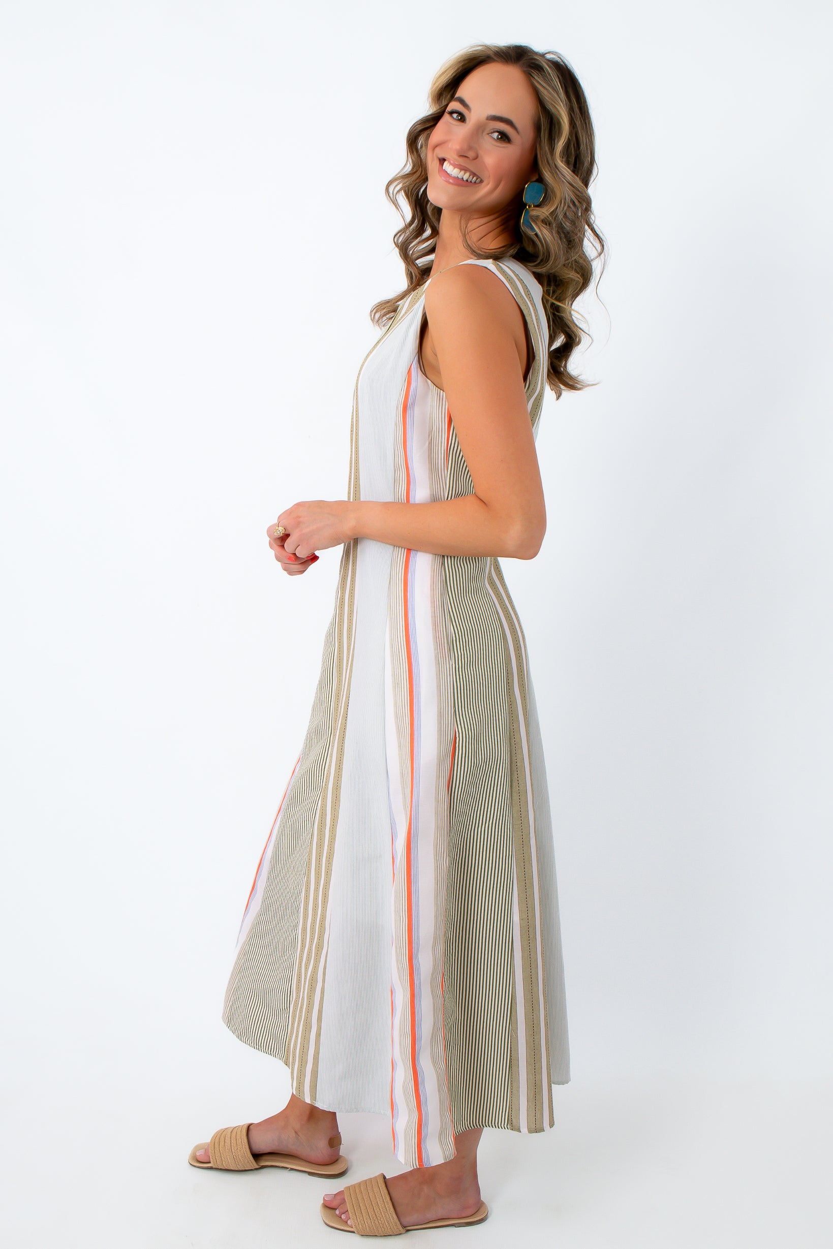 Woman in striped midi dress with side zipper and blue earrings