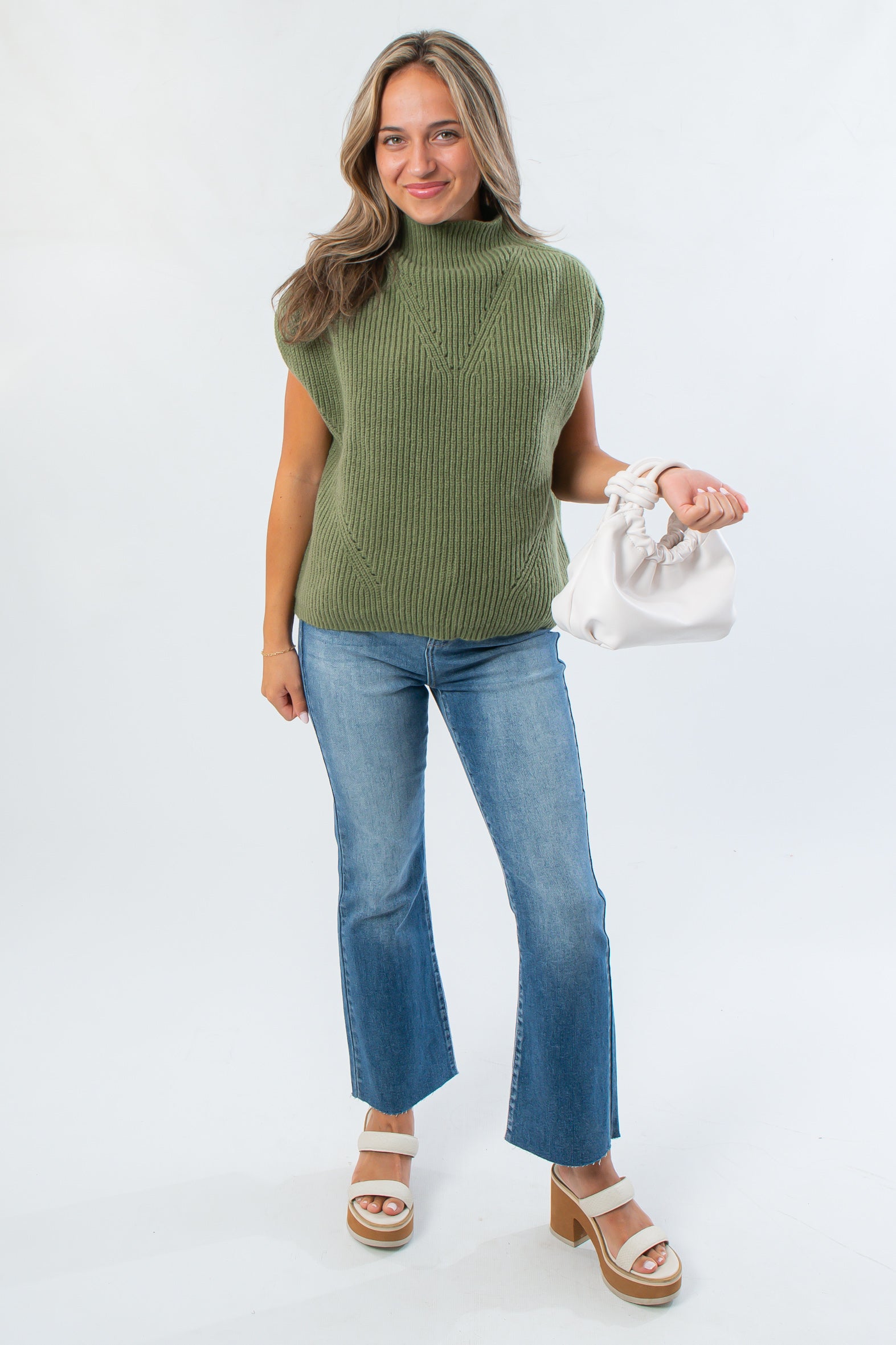 Versatile THML Green Turtleneck Ribbed Sweater Vest paired with flared jeans and platform sandals, ideal for chic autumn outfits.