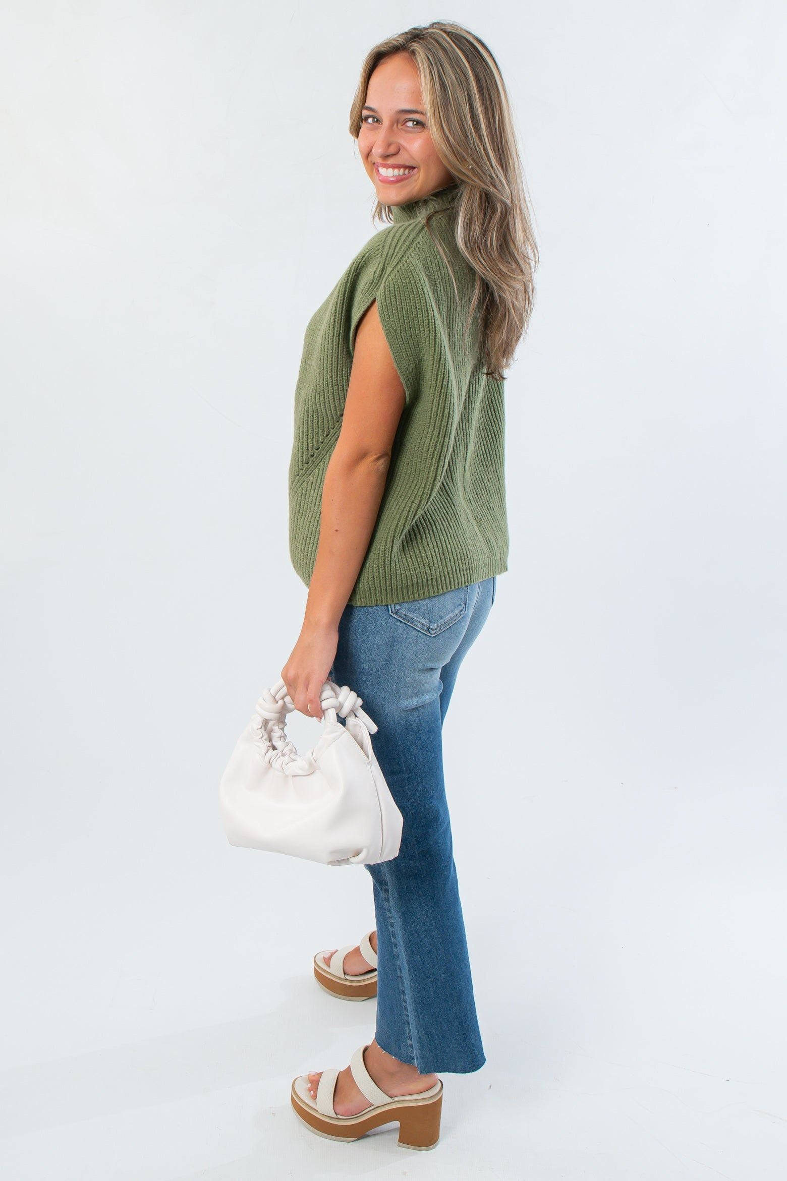 Side view of THML Green Turtleneck Ribbed Sweater Vest highlighting its relaxed fit and ribbed knit perfect for layering in cooler weather.