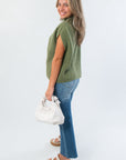 Side view of THML Green Turtleneck Ribbed Sweater Vest highlighting its relaxed fit and ribbed knit perfect for layering in cooler weather.