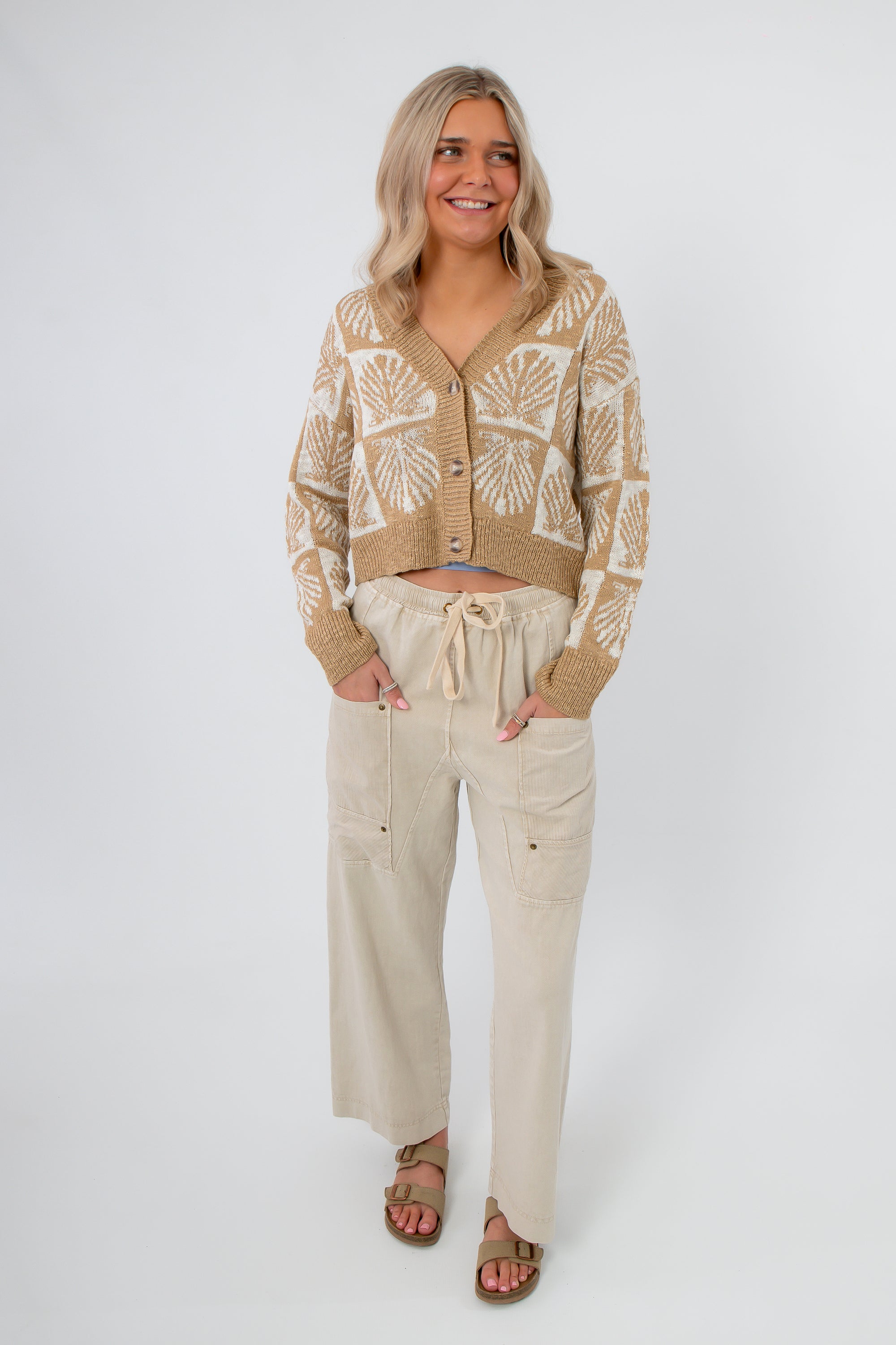 Woman wearing Breezy Natural Linen Cargo Pocket Pants styled with a knit cardigan, showcasing relaxed fit and breathable fabric for summer.